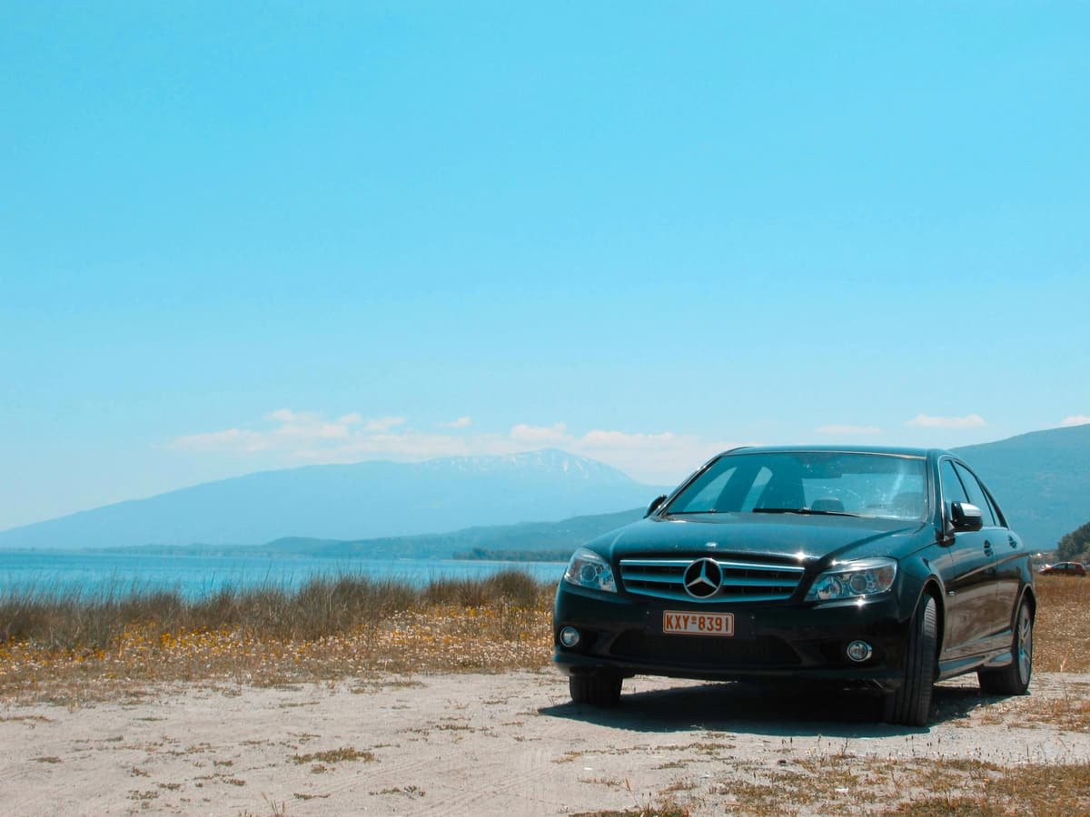 A black Novalia sedan parked facing the Mediterranean, ready for a transfer