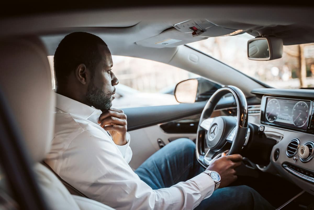 A chauffeur at the wheel of a premium sedan