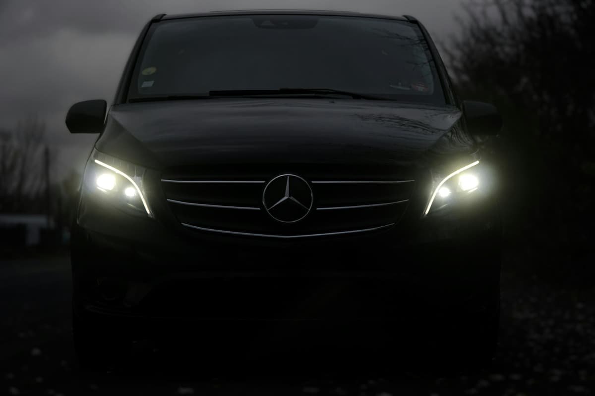 The headlights of a black car in the dark