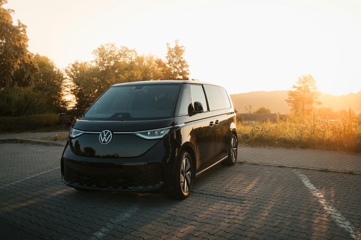 A black van on a road at sunset